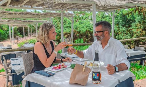 Coppia brinda a un pranzo all'aperto in un ristorante elegante.