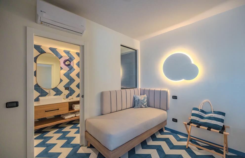 Modernes Zimmer mit TV, blauem Stuhl und Wandspiegel.